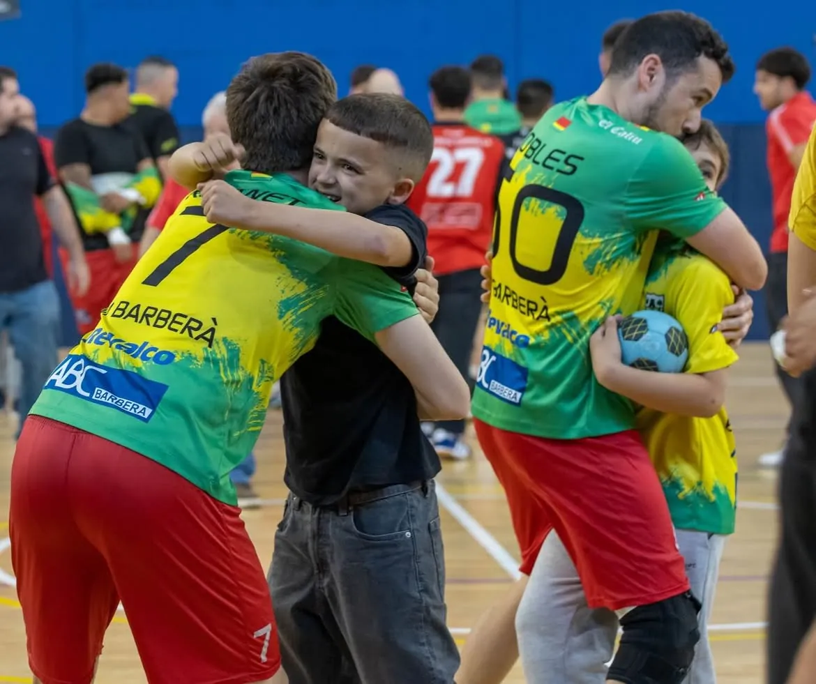 Jugadors del sènior abraçant nens de la base després d'aconseguir la permanència